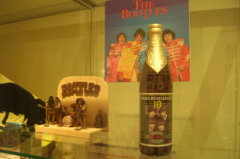 Diverse Ausstellungsstücke zu den Beatles, darunter Bierflasche mit Beatlesetikett. Foto: jvf.
